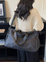Person holding a large gray bag indoors