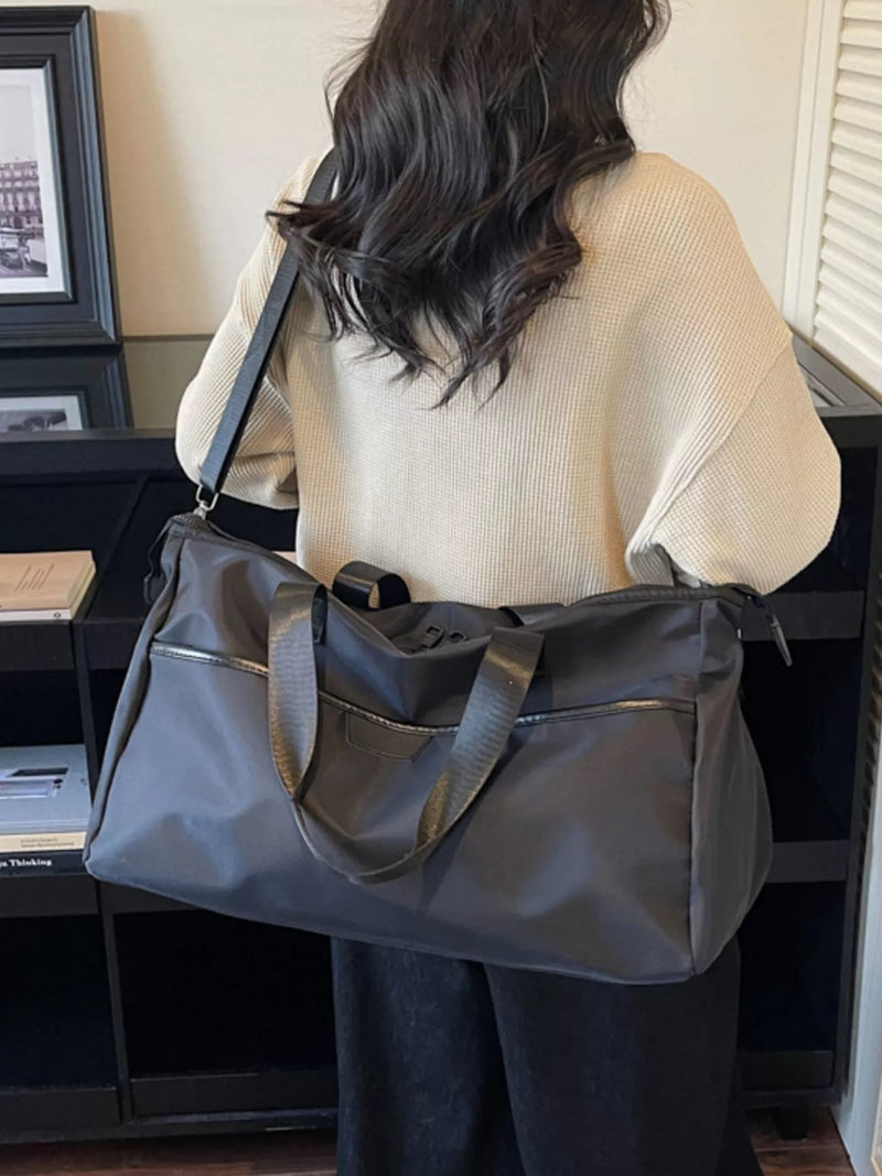 Person holding a large gray bag indoors