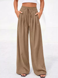 Beige wide-leg pants worn by a person on a white background