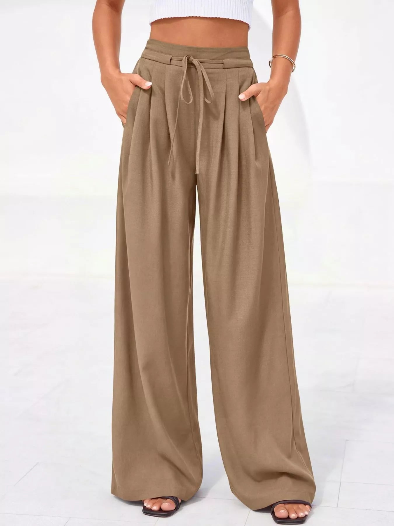 Beige wide-leg pants worn by a person on a white background
