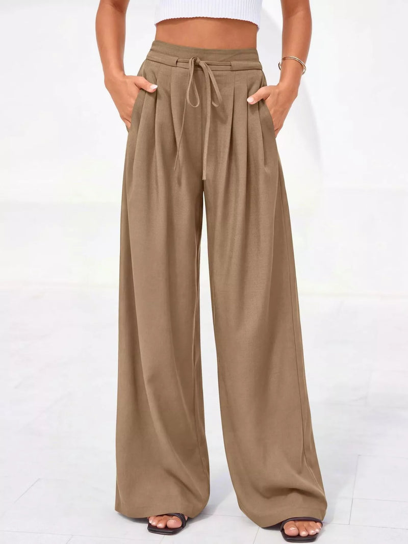 Beige wide-leg pants worn by a person on a white background