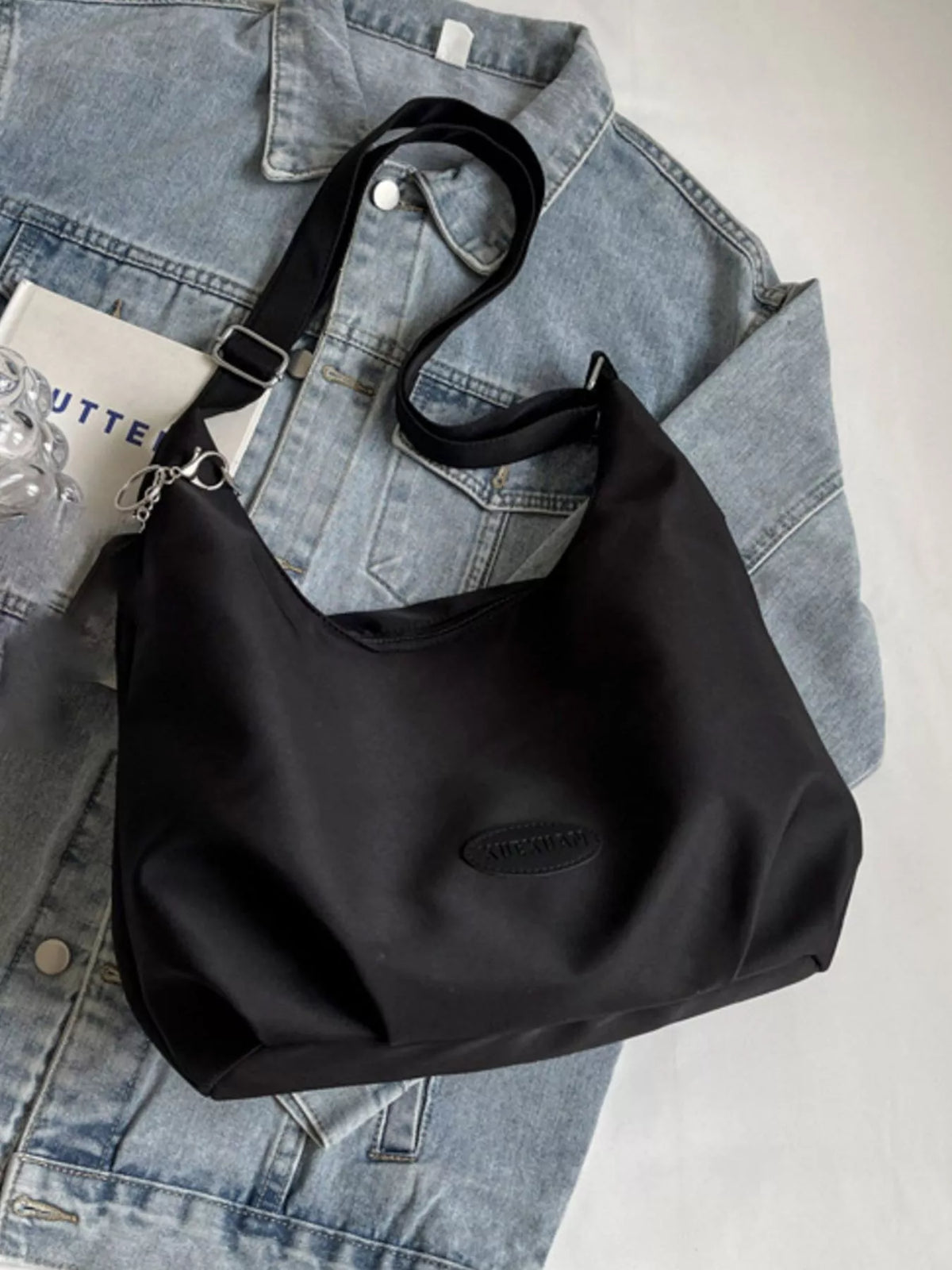 Black handbag on a denim jacket with a blurred background