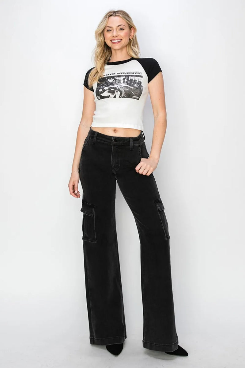 Woman wearing a graphic t-shirt and black flared jeans on a white background