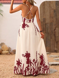 Woman wearing a white dress with red floral patterns in an outdoor setting.