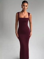 Woman wearing a burgundy evening gown against a gray background