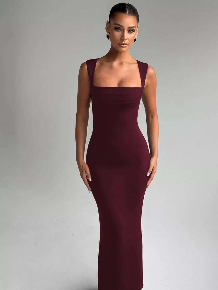 Woman wearing a burgundy evening gown against a gray background