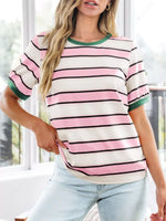 Woman wearing a striped shirt with pink, white, and green colors.