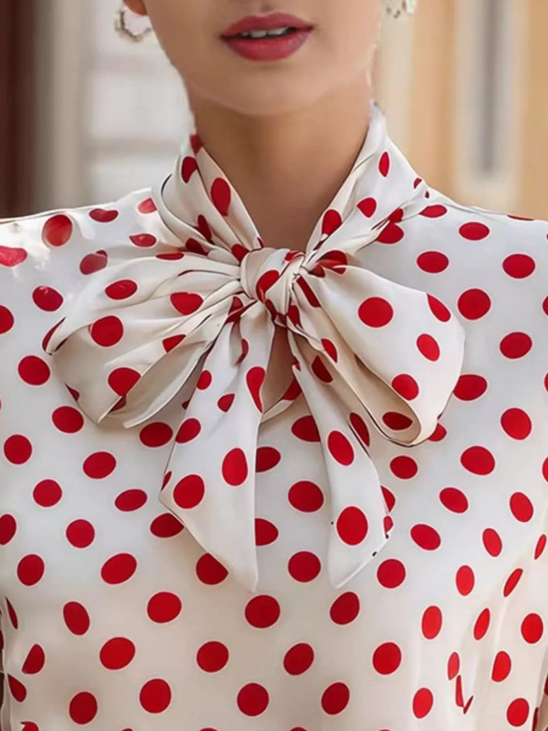 Polka dot blouse with a large bow detail on a blurred background