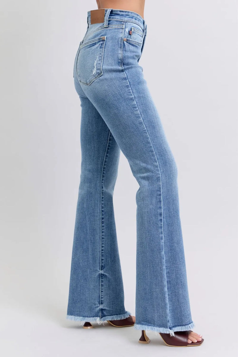Light blue flared jeans worn by a person on a white background