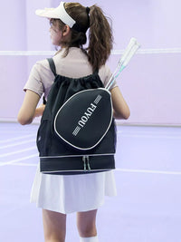 Person holding a sports bag with 'PRO' branding on a badminton court