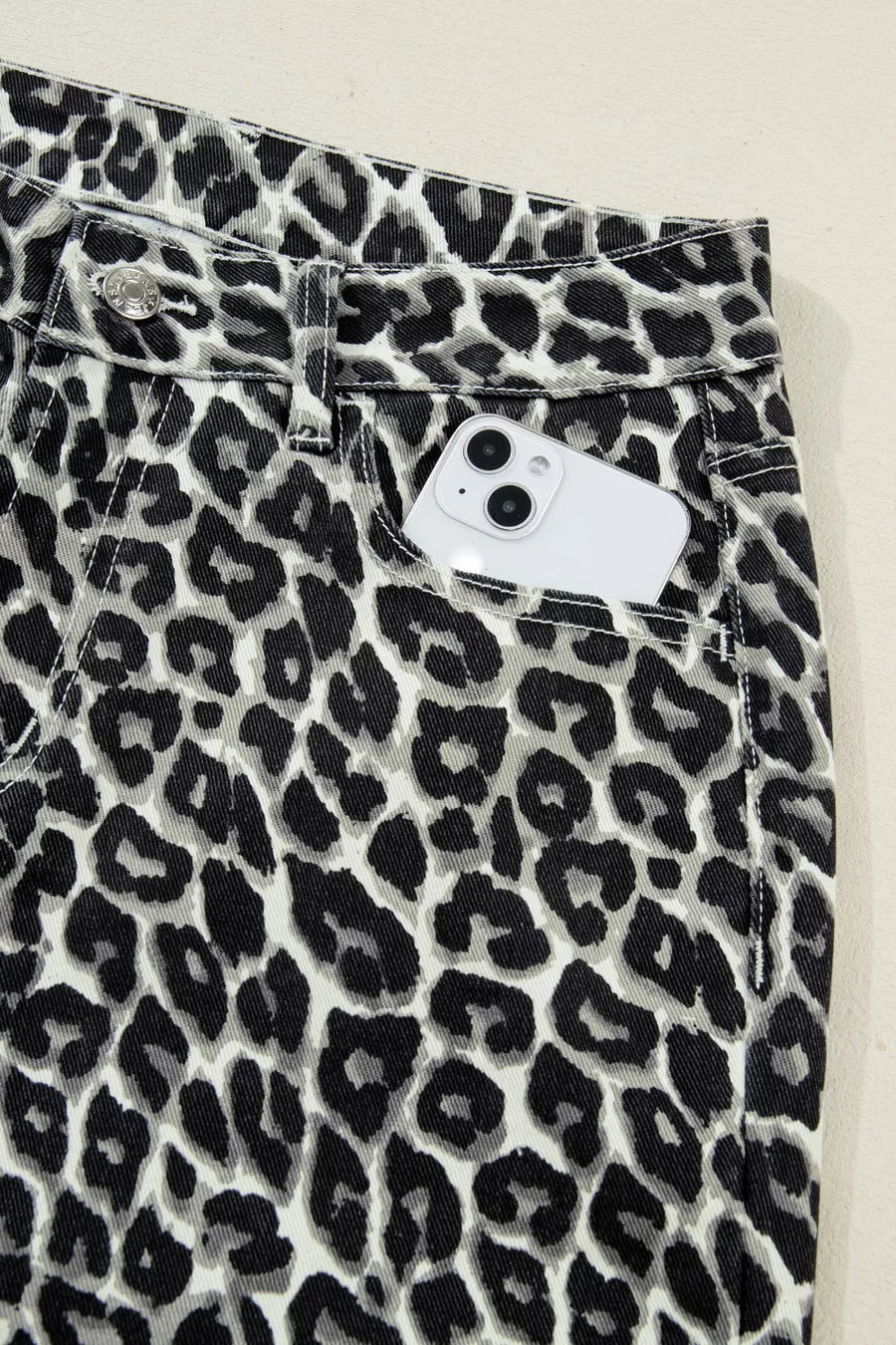 Leopard print pants with a close-up of the waistband on a light background