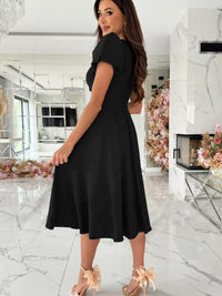 Woman wearing a black dress in a modern interior setting