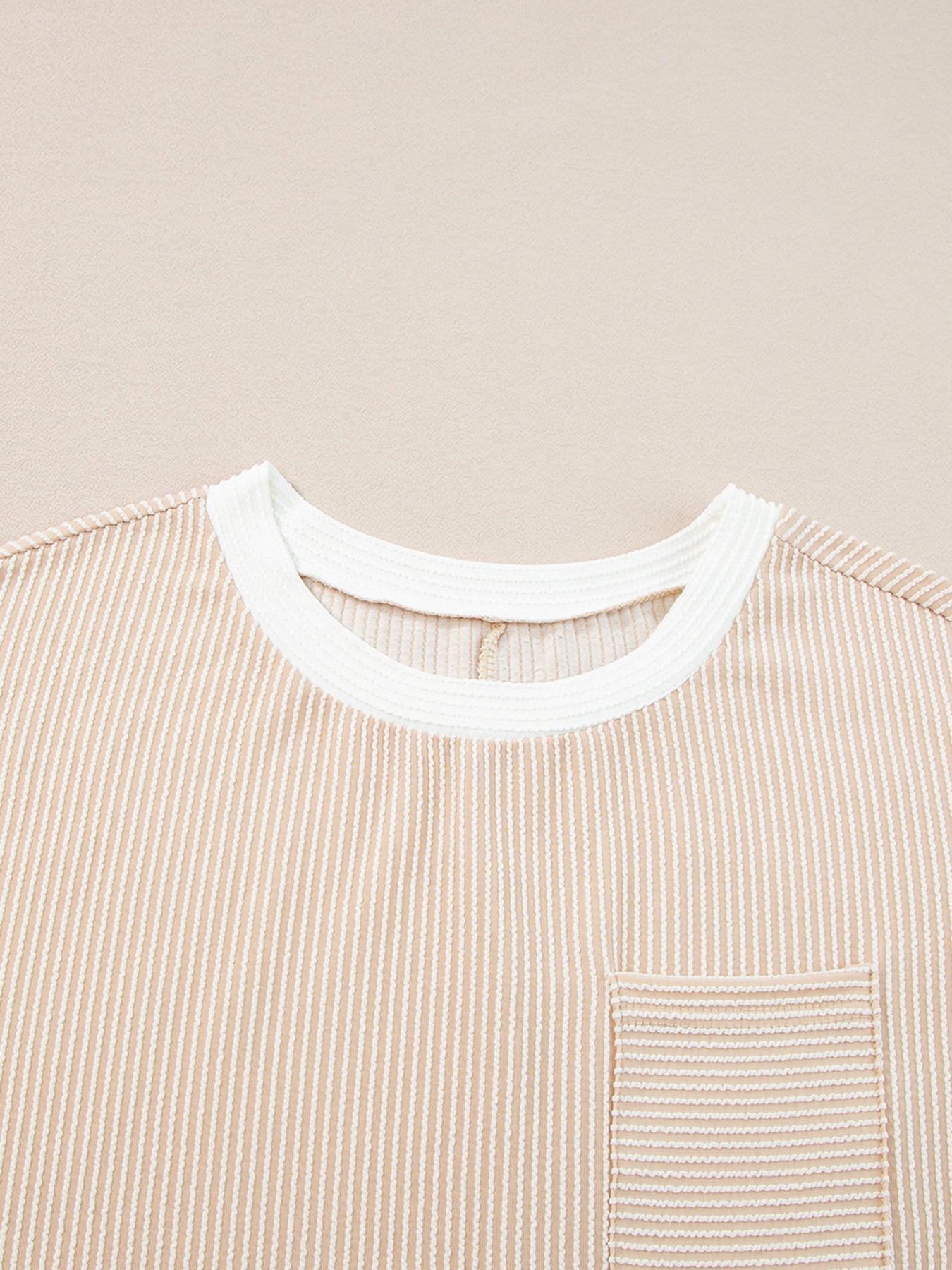 Close-up of a beige striped shirt with a white collar on a beige background
