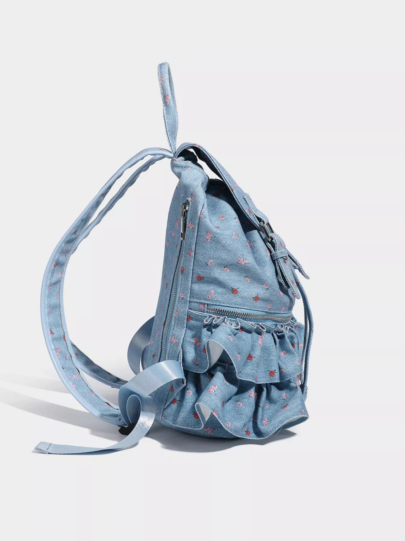 Light blue backpack with ruffled details on a white background