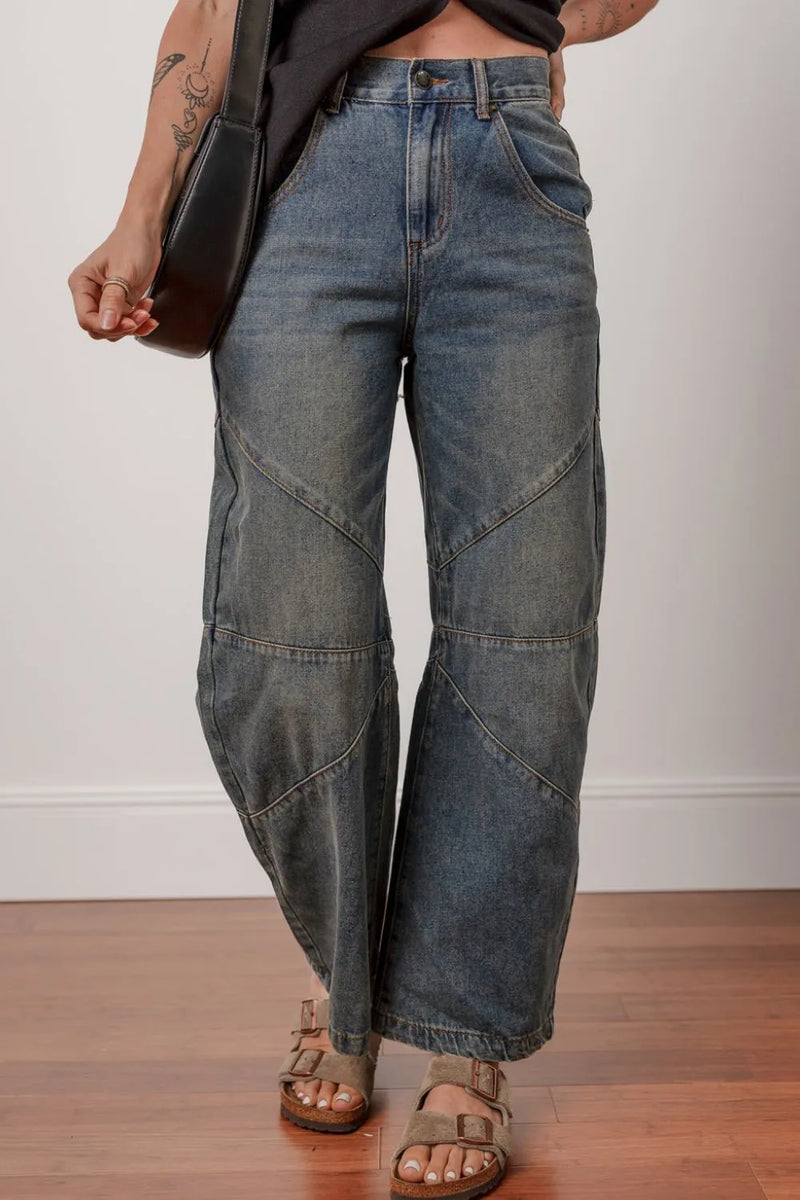 Person wearing wide-leg jeans on a plain background
