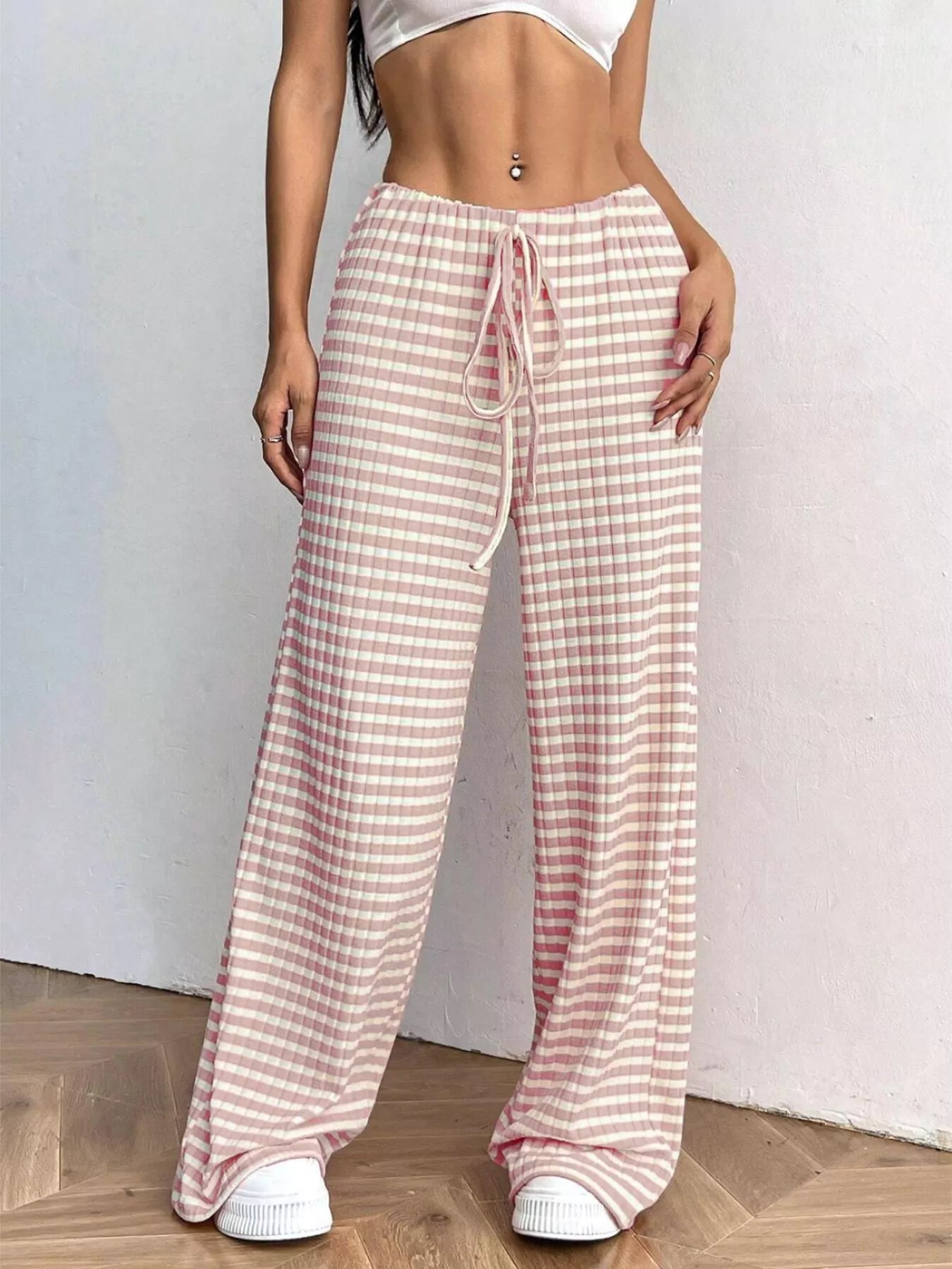 Person wearing pink and white checkered pants on a plain background