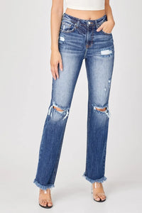 Distressed blue jeans worn by a person on a white background