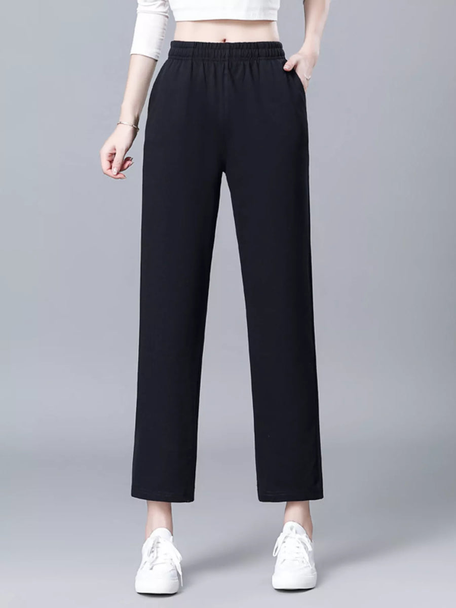 Person wearing black pants on a gray background