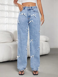 Light blue jeans with white bows worn by a person in a minimalistic room.