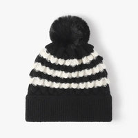 Black and white striped beanie with a pom-pom on a white background