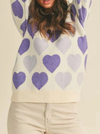 Person wearing a sweater with purple and light purple heart patterns on a beige background