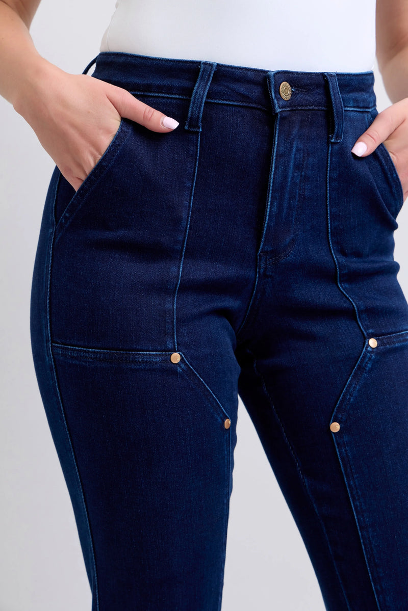 Navy blue jeans with gold buttons on a light gray background