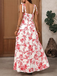Woman wearing a white dress with red floral pattern indoors.