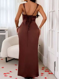 Woman wearing a brown dress with a backless design in a room with white walls and a white chair.