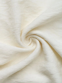 Close-up of cream-colored fabric with a swirl pattern
