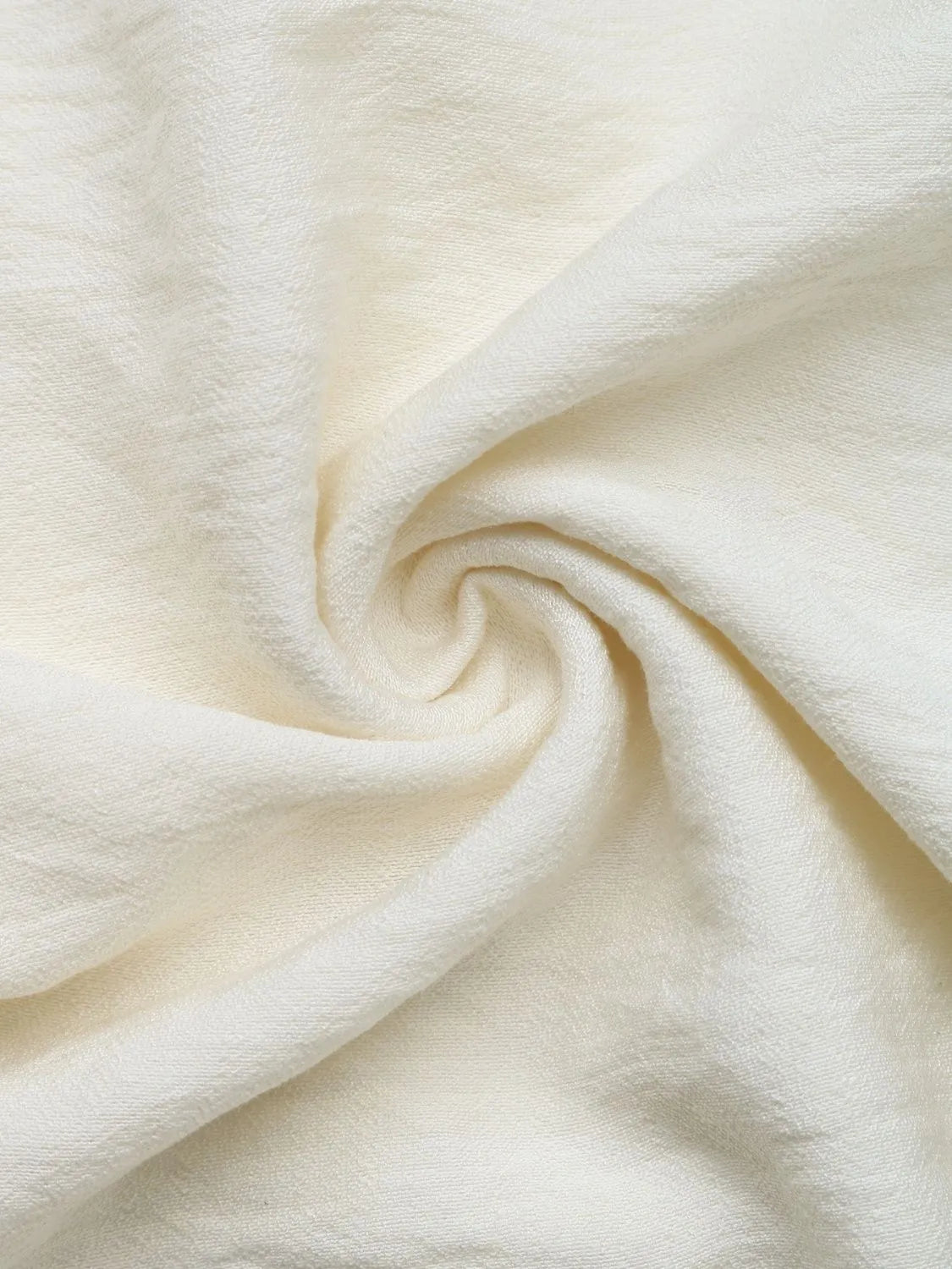 Close-up of cream-colored fabric with a swirl pattern