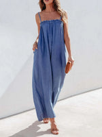 Woman wearing a blue jumpsuit against a white background
