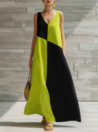 Woman wearing a black and green dress against a stone wall.