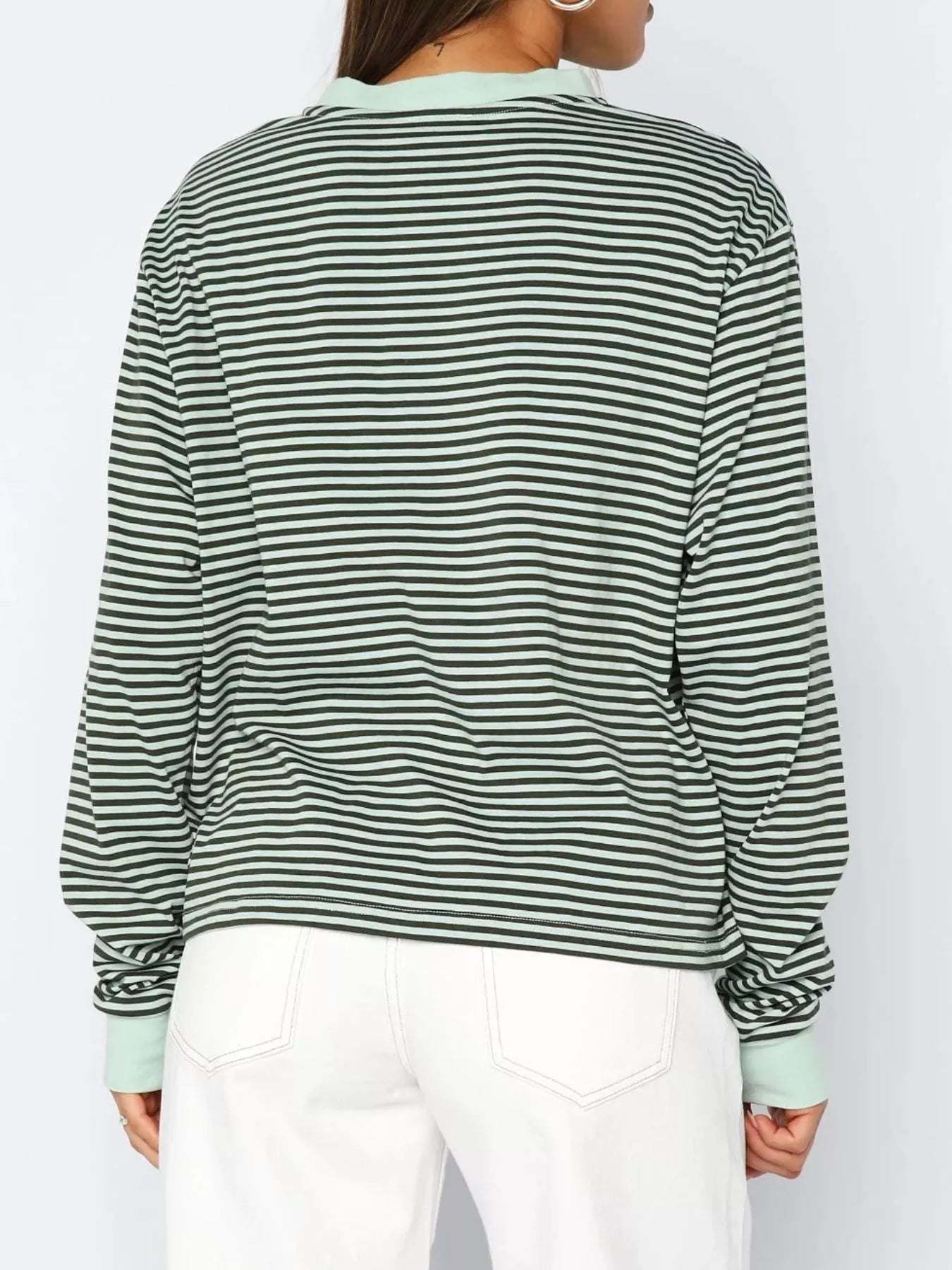 Green and black striped shirt worn by a person on a white background