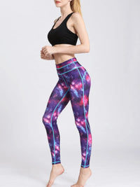 Person wearing a black sports bra and galaxy-themed leggings on a white background