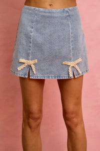 Denim skirt with bow details on a pink background