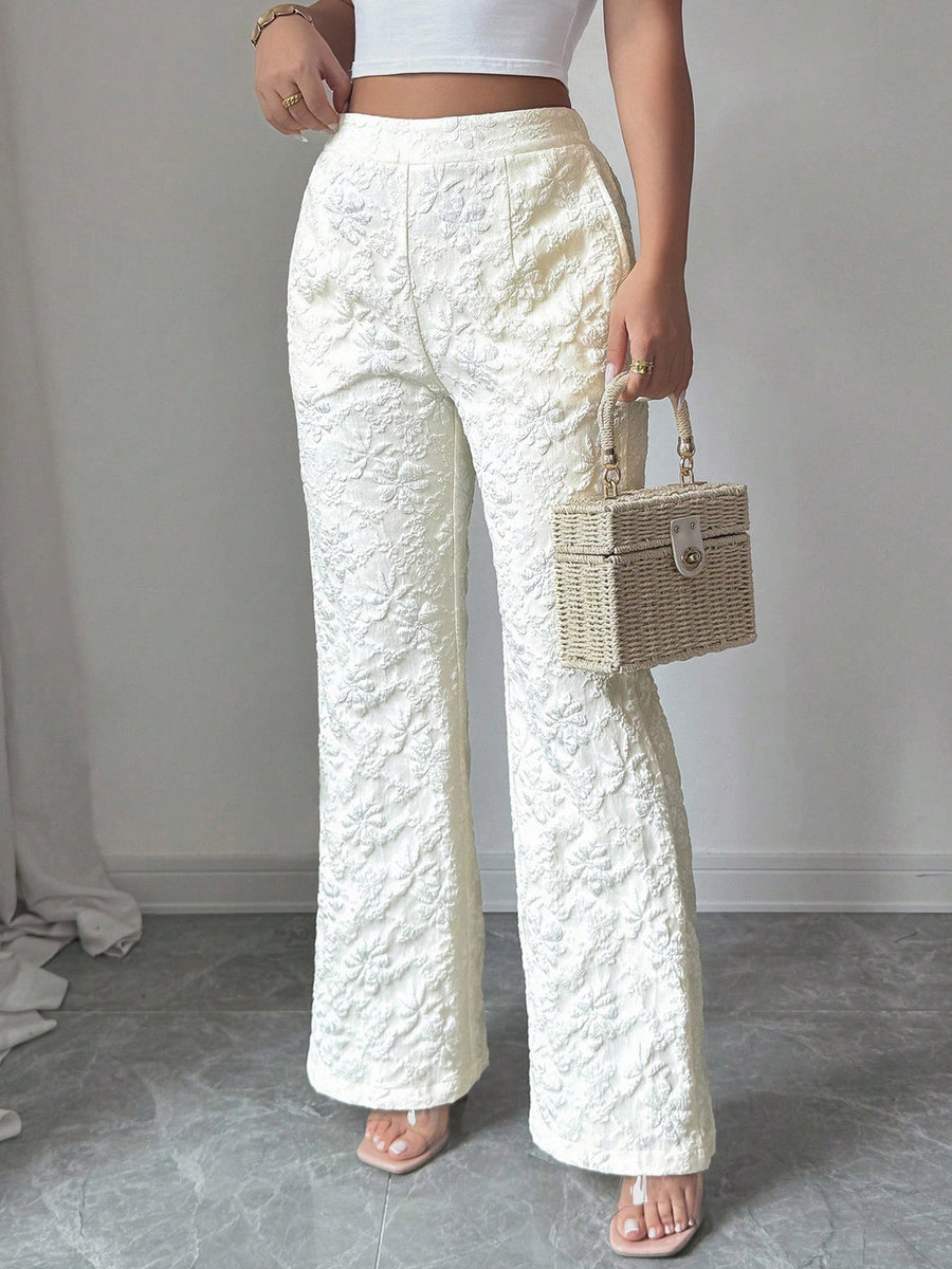 Person wearing white textured pants holding a wicker handbag against a plain background