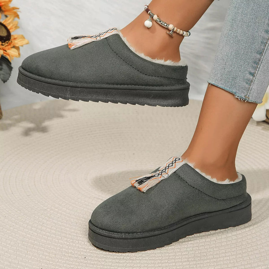 Gray slip-on shoes with white lining worn by a person on a neutral background