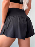 Black athletic skirt worn by a person on a light gray background