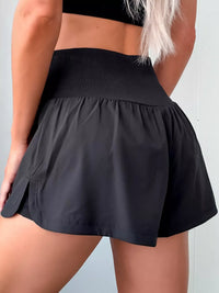 Black athletic skirt worn by a person on a light gray background