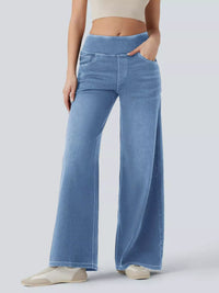 Person wearing light blue wide-leg jeans on a plain background