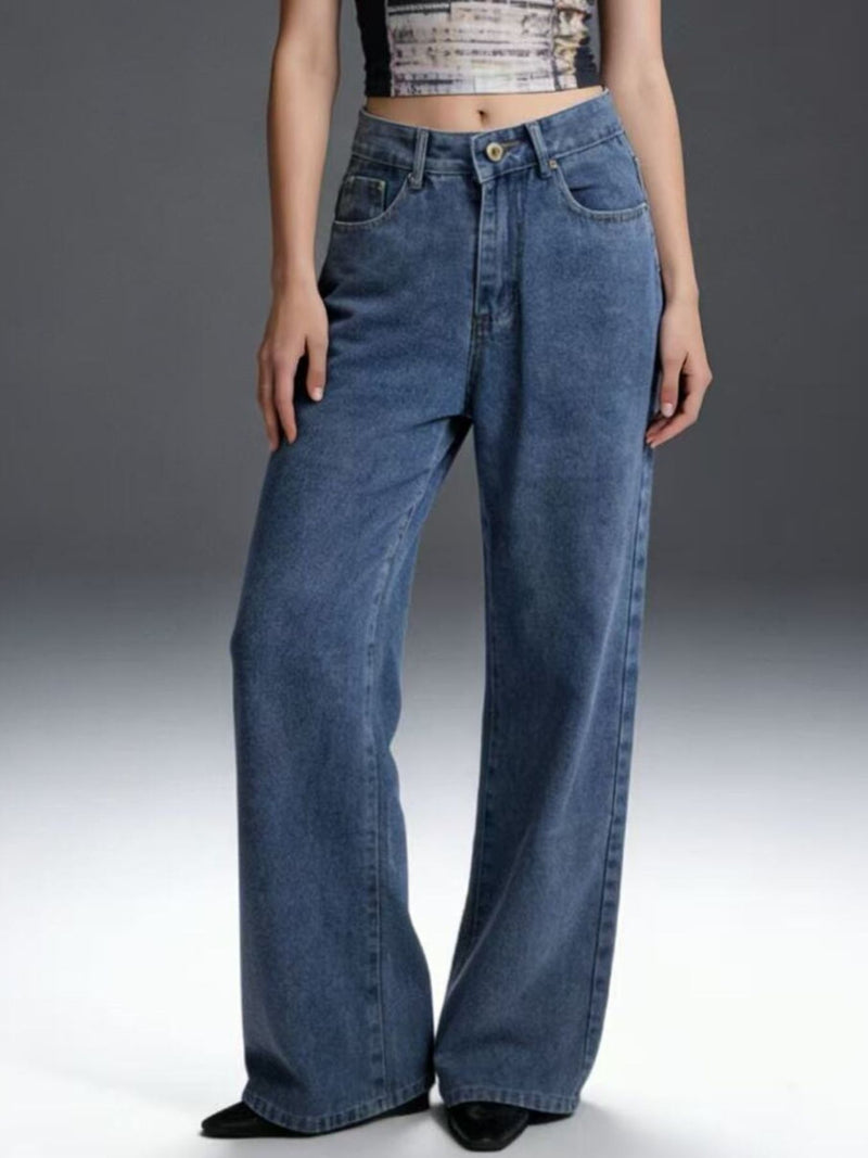 Person wearing blue jeans on a plain background