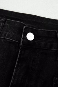 Close-up of a button on black pants against a white background