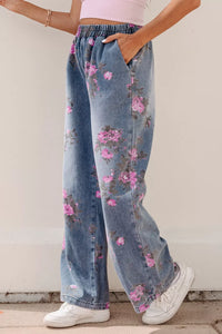 Person wearing floral denim pants with a plain background