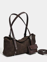 Brown leather handbag with shoulder straps on a light gray background