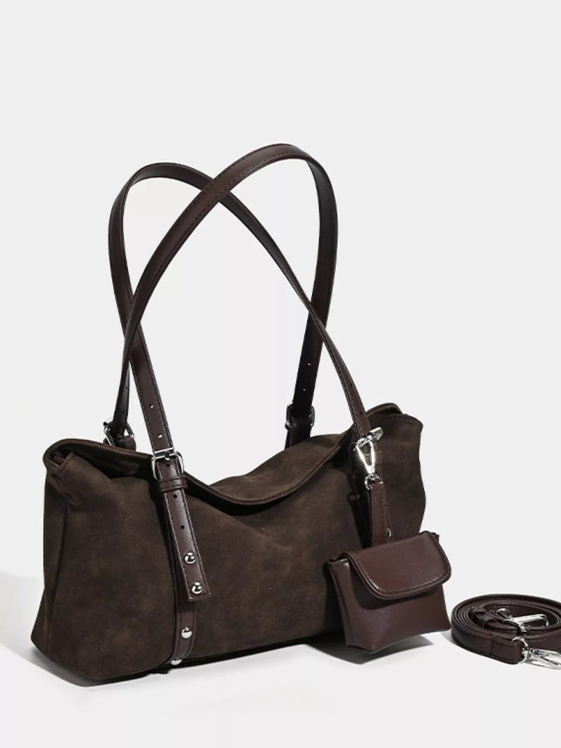 Brown leather handbag with shoulder straps on a light gray background