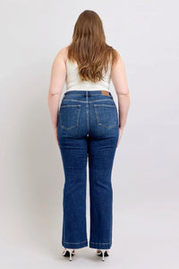 Person wearing blue jeans from behind on a plain background