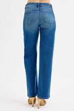 Blue jeans worn by a person on a white background