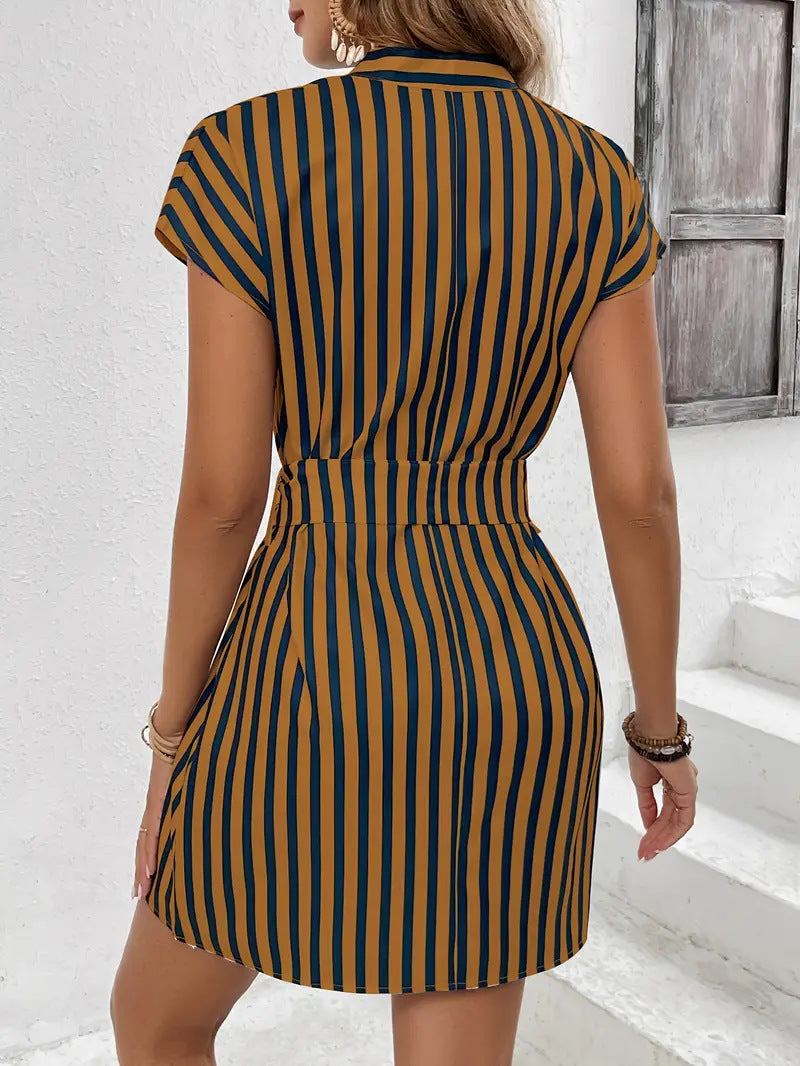 Woman wearing a striped dress with a white wall and wooden door in the background