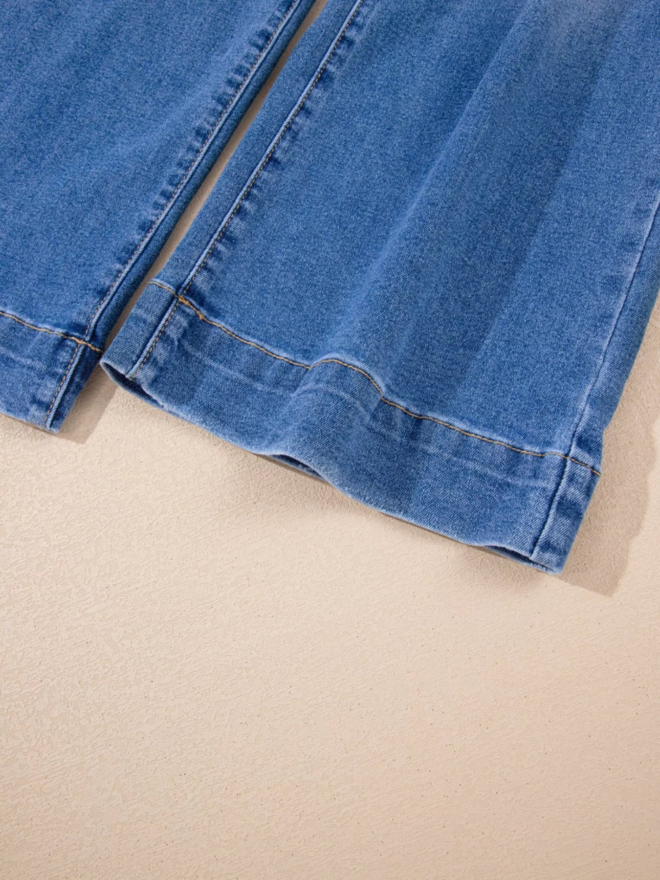 Close-up of blue denim fabric on a beige background