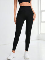 Person wearing black leggings and a black top on a white background